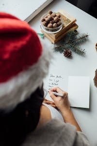 Child writing a letter to Santa with Christmas decor on a cozy winter day.