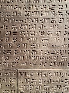 Close-up of ancient cuneiform script on a stone tablet, showcasing Mesopotamian writing.